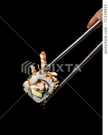 Japanese and Asian cuisine sushi roll Chinese chopsticks with fresh  eel and tuna ingredients over black background with text copy space 71339915