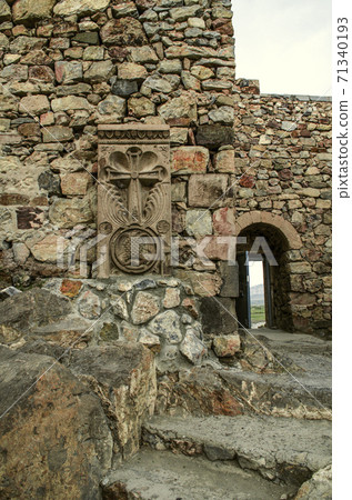 Khachkar at the wall in the courtyard of the medieval fortress Khor Virap and staircase leading to an arched passage with an emergency exit 71340193