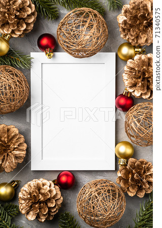 Christmas composition with empty picture frame. Golden ornament, pine cones and fir needles decorations. Mock up greetings card template Christmas composition with empty picture frame. Golden ornament, pine cones and fir needles decorations. Mock up greetings card template 71340575