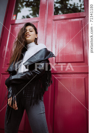 Young woman outdoor against a red door Young woman outdoor against a red door 71341180