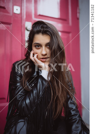 Young woman outdoor against a red door Young woman outdoor against a red door 71341182