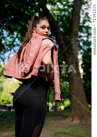 Young woman is resting after jogging in the park. 71341315