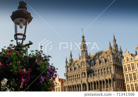 Brussels, Belgium, August 2019. The Great Square or Grote Markt. The evening light enhances its beauty of the magnificent Baroque and Gothic buildings. A lamppost decorated with a planter is the frame Brussels, Belgium, August 2019. The Great Square or Grote Markt. The evening light enhances its beauty of the magnificent Baroque and Gothic buildings. A lamppost decorated with a planter is the frame 71341506