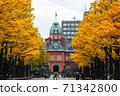 Row of ginkgo trees colored in yellow and red brick government building 71342800