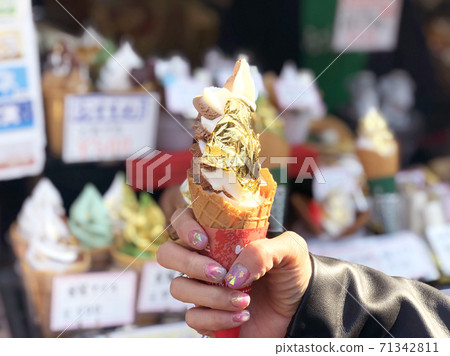 Ice cream cone covered with real gold leaf a famous street food in Japan Ice cream cone covered with real gold leaf a famous street food in Japan 71342811