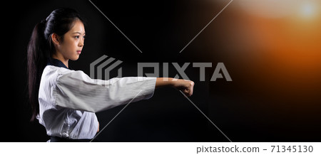 TaeKwonDo Karate teenager athlete kick punch black background isolated 71345130