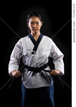 TaeKwonDo Karate teenager athlete kick punch black background isolated 71345135