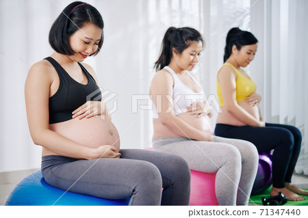 Pregnant women sitting on fitness balls 71347440