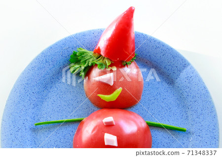 Snowman of tomatoes, peppers, ham and herbs on a plate. Christmas decor from food. Isolated on a white background. Copy space 71348337