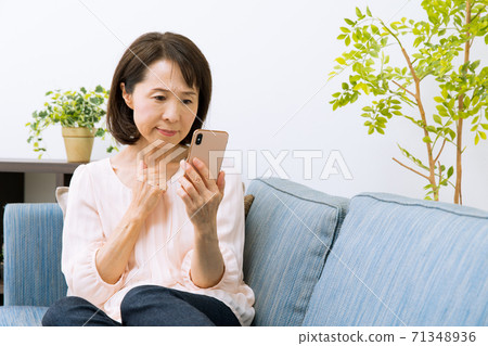 看著智能手機的女人感到驚訝和困擾 71348936