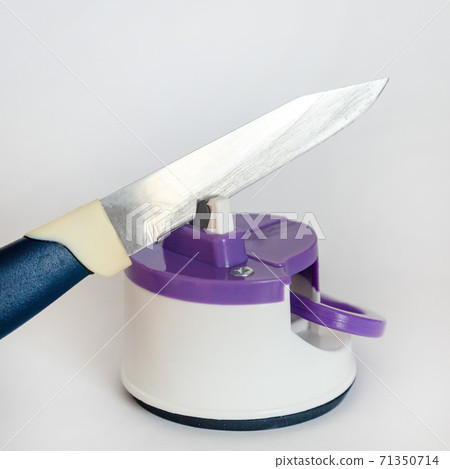 Kitchen knife and compact knife sharpener on white background Kitchen knife and compact knife sharpener on white background 71350714