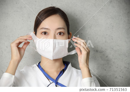 Female health care worker wearing a mask up 71351563