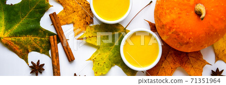 Autumn food. Pumpkin puree soup, leaves. Top view. Autumn harvest, pumpkins, leaves on grey as abstract background. Thanksgiving day. Flat lay. Autumn food. Pumpkin puree soup, leaves. Top view. Autumn harvest, pumpkins, leaves on grey as abstract background. Thanksgiving day. Flat lay. 71351964