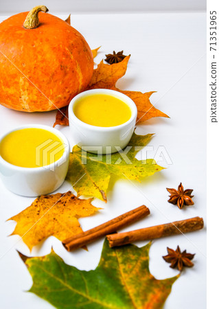 Autumn food. Pumpkin puree soup, leaves. Autumn harvest, pumpkins, leaves on grey as abstract background. Thanksgiving day. 71351965