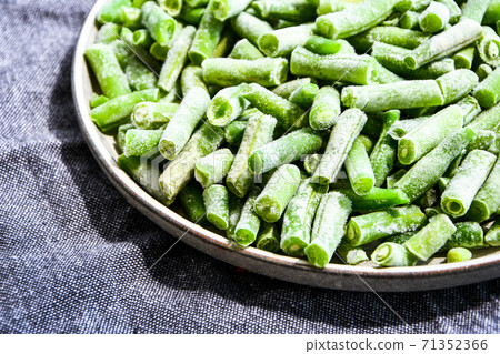 Fresh frozen green beans in a plate. Stocking up vegetables for winter storage. Fresh frozen green beans in a plate. Stocking up vegetables for winter storage. 71352366