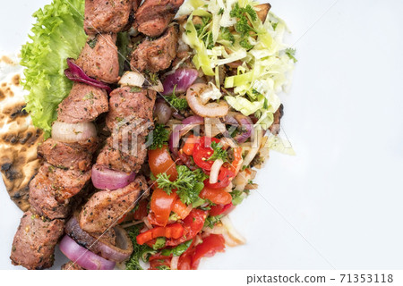 Traditional Greek souvlaki barbecue skewer with cabbage and tomato onion salad 71353118