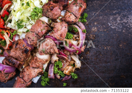 Traditional Greek souvlaki barbecue skewer with cabbage and tomato onion salad  71353122
