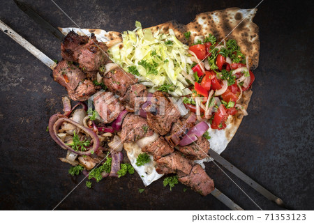 Traditional Greek souvlaki barbecue skewer with cabbage and tomato onion salad  71353123