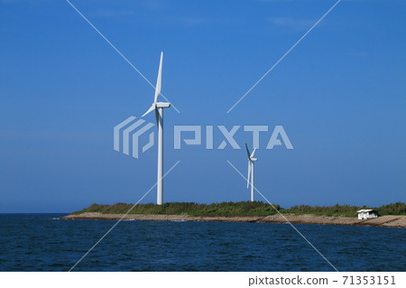 A windmill standing on the beach in the blue sky 71353151