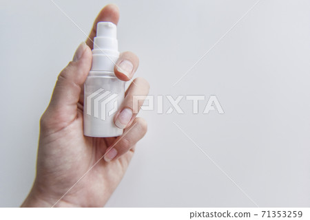 holding in hand the tube with some white liquid in it 71353259