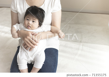 Mother in her 30s and baby sitting on her lap, 0 years old, 4 months old, girl 71355175