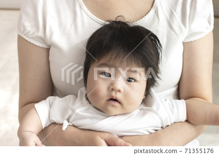 Mother in her 30s and baby sitting on her lap, 0 years old, 4 months old, girl 71355176