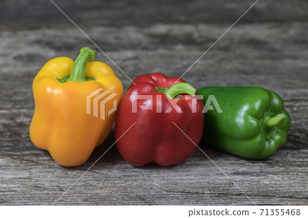 Colored peppers standing on an old wooden table Colored peppers standing on an old wooden table 71355468