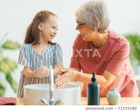 girl and her grandmother are washing hands girl and her grandmother are washing hands 71355590