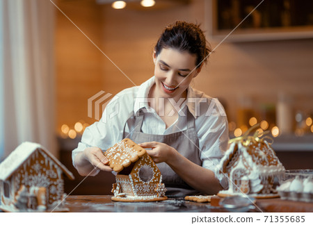 Woman cooking gingerbread house Woman cooking gingerbread house 71355685