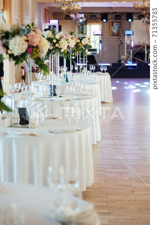 A beautiful vase of flowers on a table in a luxury restaurant. Wedding decorations A beautiful vase of flowers on a table in a luxury restaurant. Wedding decorations 71355785