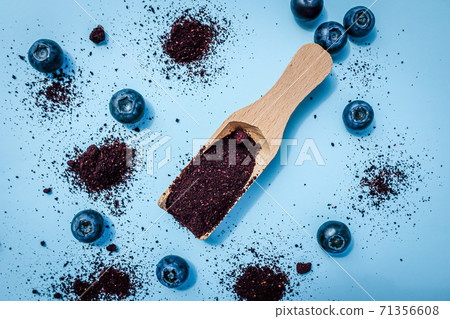 Dried blueberry powder on a wooden scoope Dried blueberry powder on a wooden scoope 71356608