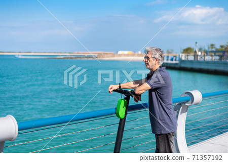 Senior man taking rest while having a ride on electric scooter 71357192