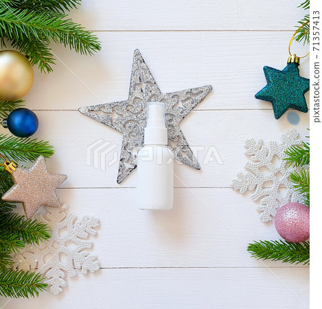 Top view of white spray bottle mockup, fir branches, stars, balls on a white wooden table. Blank label bottle for branding. Natural organic spa cosmetics concept. Close-up, Christmas flatlay. Top view of white spray bottle mockup, fir branches, stars, balls on a white wooden table. Blank label bottle for branding. Natural organic spa cosmetics concept. Close-up, Christmas flatlay. 71357413