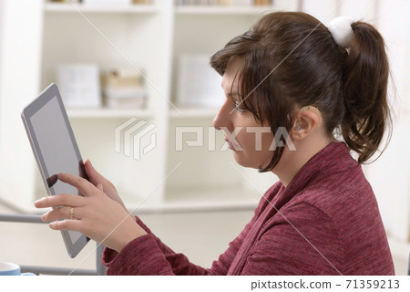 Deaf woman using tablet Deaf woman using tablet 71359213