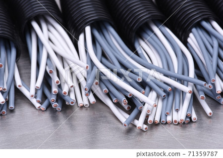 Electric cables in corrugated plastic pipes on metal surface 71359787