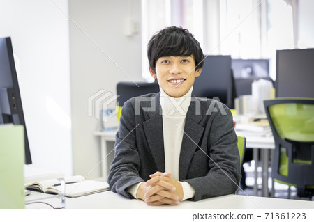 A young man looking at the camera and smiling A young man looking at the camera and smiling 71361223