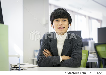 A young man looking at the camera with wireless headphones 71361225