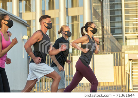 Young mixed race team in protective masks training outdoors 71361644