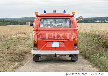 Wedding Couple in Oldtimer VW T1 fire engine red firefigther car classic car drivin on the Road Wedding Couple in Oldtimer VW T1 fire engine red firefigther car classic car drivin on the Road 71362309