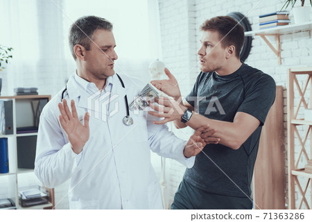 Doctor in a white coat refuses a bribe from a man. Doctor in a white coat refuses a bribe from a man. 71363286