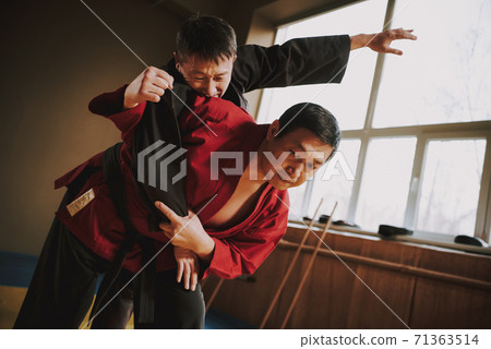 A master in a red kimono throws an opponent. A master in a red kimono throws an opponent. 71363514