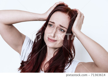 Woman holds hands on her head and feels headache. 71363614