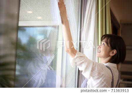 Woman cleaning the window 71363913