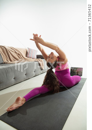 Beautiful young woman working out indoors, doing yoga exercise on gray mat at home 71365432