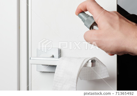 Cleaning door handle with spray 71365492