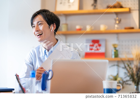 遠程辦公微笑的年輕人在他的客廳裡有一個網絡會議 71365832