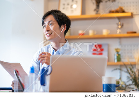 遠程辦公微笑的年輕人在他的客廳裡有一個網絡會議 71365833