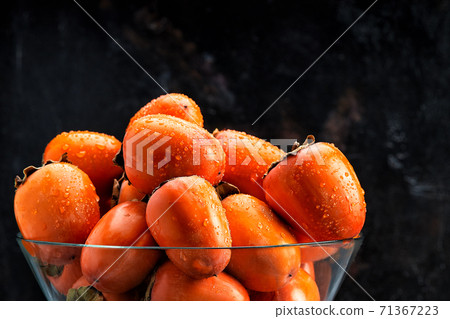 Delicious raw ripe persimmon fruit on dark rusty metal background copy space 71367223