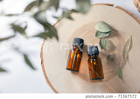 Two wood and two aroma oil bottles. Image of nature, organic and beauty. Two wood and two aroma oil bottles. Image of nature, organic and beauty. 71367572
