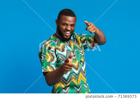 Happy african american guy demonstrating traditional bright clothes 71369373